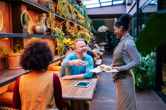 Waitress serving food and drink to customers