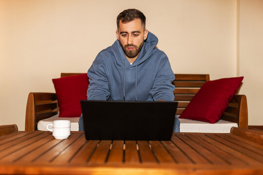 Man working on laptop at home focused on screen