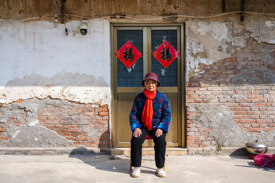 Elderly woman sitting at doorway