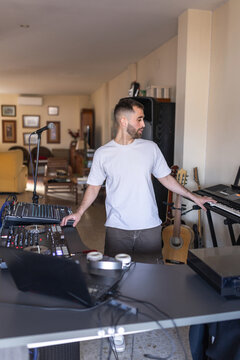Man in home music studio with piano and dj equipment
