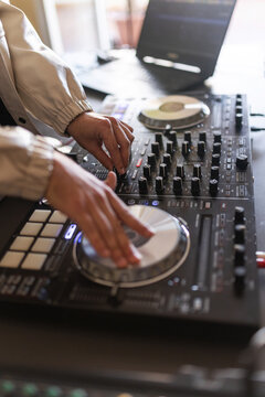 Close up of dj hands mixing music on controller