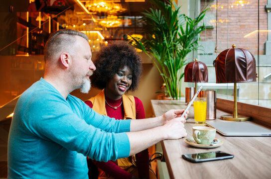 Diverse couple discussing content on digital tablet