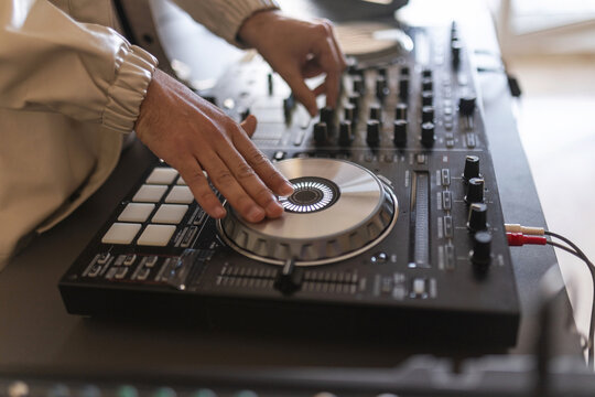 Close up of dj hands mixing music on controller
