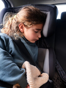 Child sleeping safely in car seat during journey