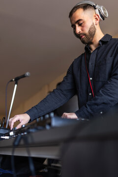 Dj mixing music at home studio with headphones