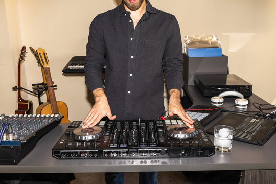 Bearded man dj mixing music at home party