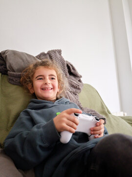 Child playing video games smiling happily at home