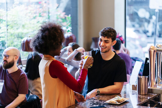 Diverse friends enjoying drinks and socializing at bar