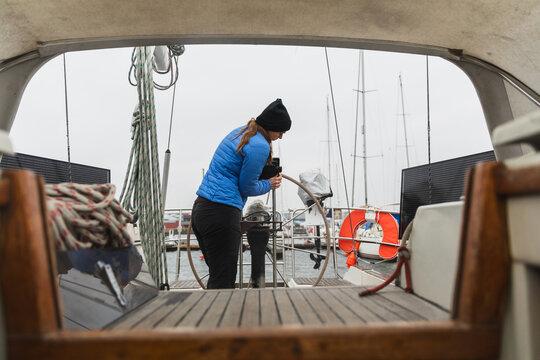 Female Sailor Working on Sailboat Deck Seen from Cabin Interior