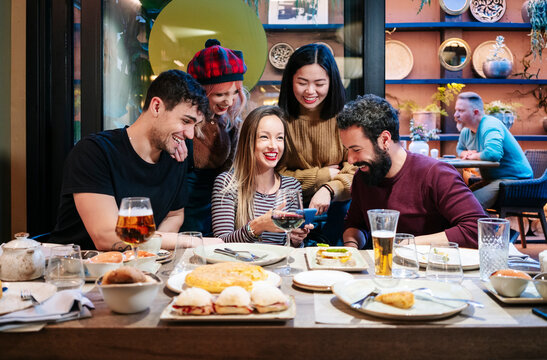 Diverse friends laughing and sharing a memorable dinner