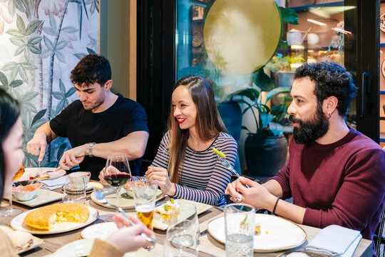 Friends enjoying dining and conversation at restaurant