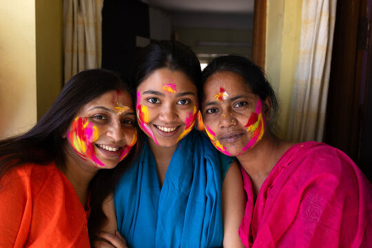 Indian woman playing holi with faces smudged with colour powder