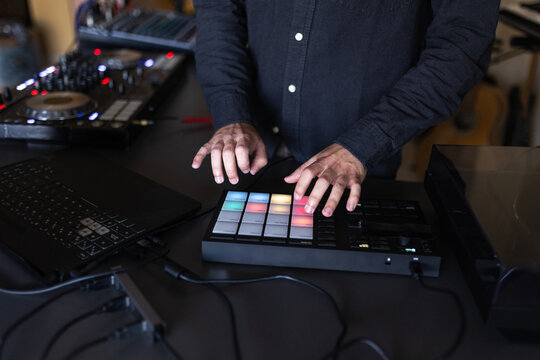 Close up of dj hands pressing colorful pad controller