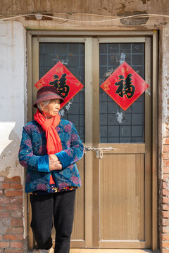 Elderly woman at Chinese doorway