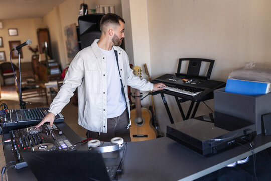 Man in home music studio with piano and dj equipment