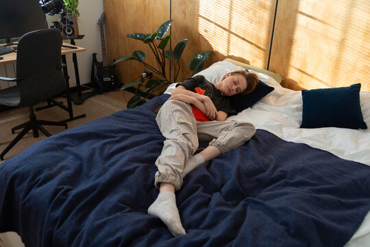 Person experiencing abdominal pain, applying warming bottle for relief