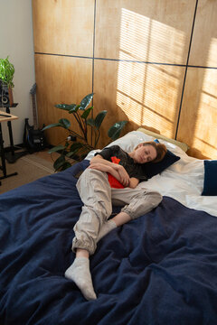Person relieving abdominal discomfort in bed with hot water bottle