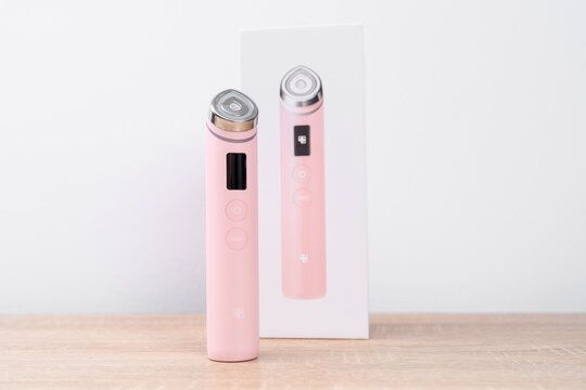 Bar, Montenegro: February 6, 2026: Pink facial beauty device Medicub Booster pro standing upright on surface against a minimal white background in the shop window, modern skincare product concept