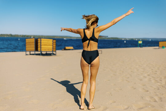Woman Walks on the Beach With Sand and Water on a Sunny Day