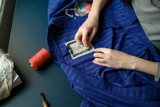 A female designer sews a tag onto a product
