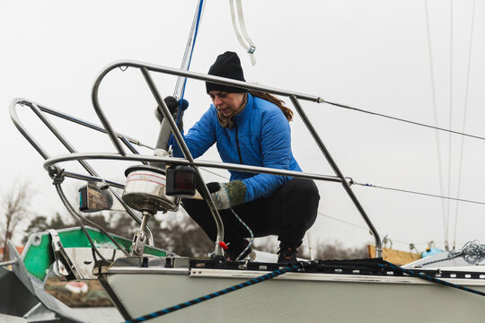 Female Sailor Inspecting Anchor and Furling System at Yacht Bow