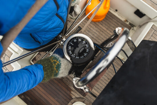 Close Up of Sailor Hand on Steering Wheel with Compass