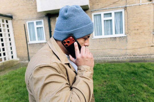 Man talking on smartphone outside building