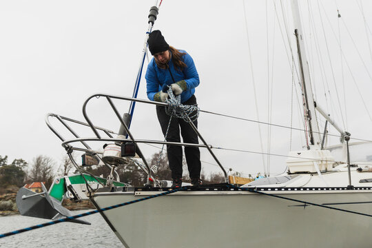 Female Sailor Handling Anchor and Lines at Sailboat Bow