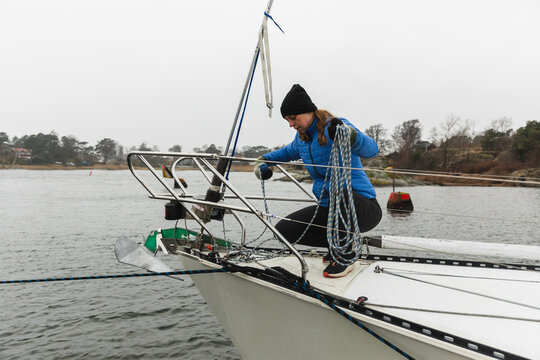 Female Sailor Handling Anchor and Lines at Sailboat Bow