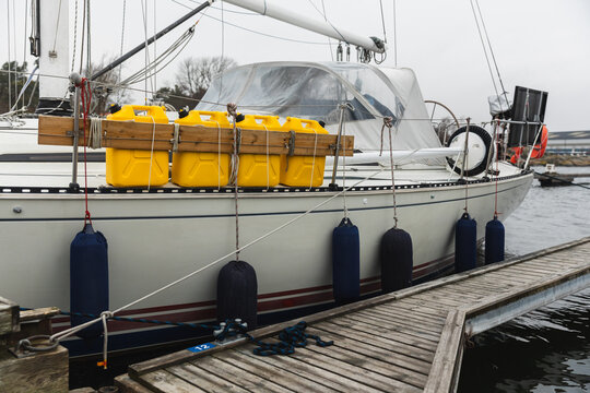 Sailboat Moored at Wooden Dock with Fenders and Fuel Tanks