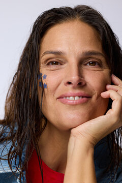 Woman Smiles While Showing Blue Star Face Paint in Studio