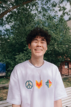 Smiling Young Man with Curly Hair in Park