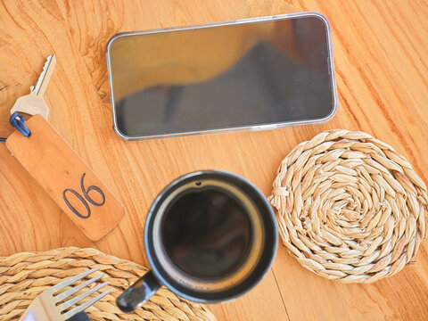 Coffee Cup and Smartphone on Wooden Table in Cafe Setting