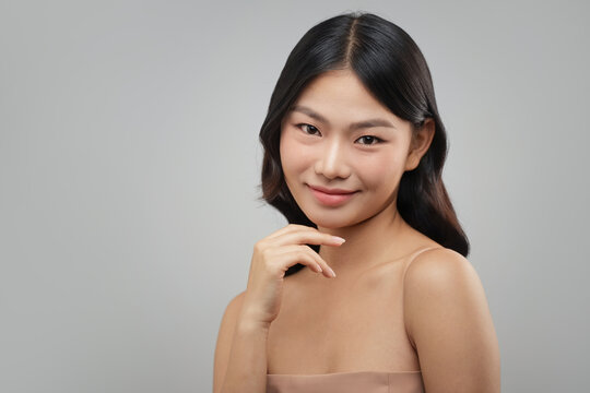 Beautiful Asian woman with flawless skin smiles gently