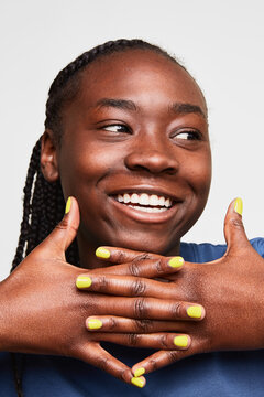 Smiling woman displaying vibrant yellow manicure nails