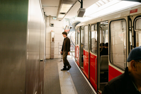young man stepping out of train / tram/ funiculaire in Lyon