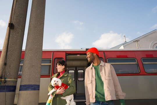 Couple Walking With Dog At Train Station Platform