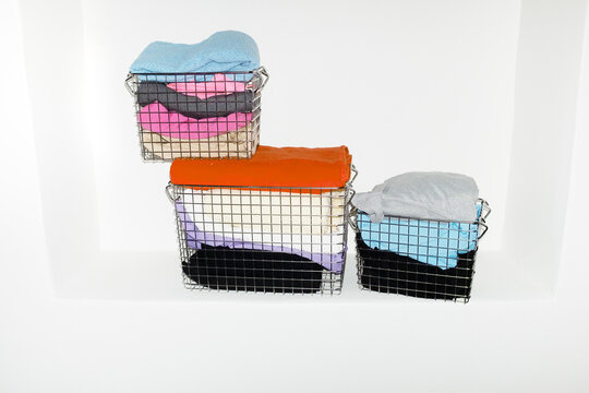 Silver wire baskets full of colourful fabrics and clothes with flash