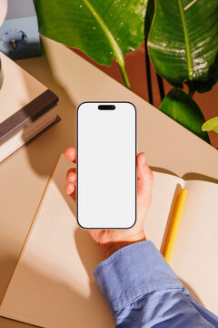 Phone mockup with white screen at desk workspace