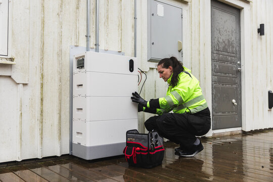 Technician Inspecting Home Battery Energy Storage System