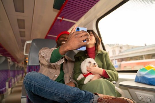 Couple Taking Selfie While Traveling on a Train With a Dog