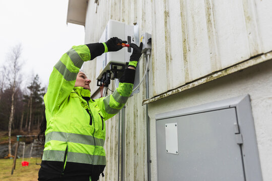 Female Electrician Inspecting Residential Electrical Panel
