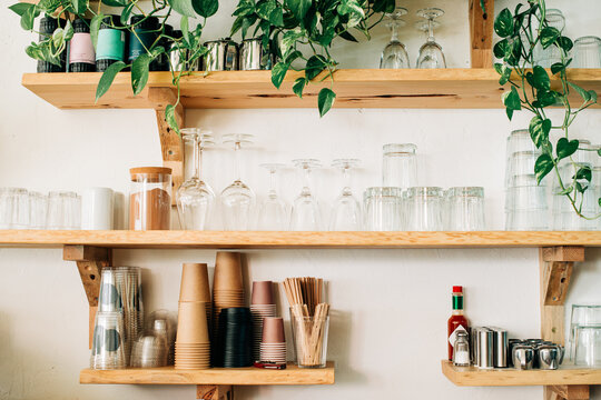 Cafe shelving with glasses paper cups and decorative plants