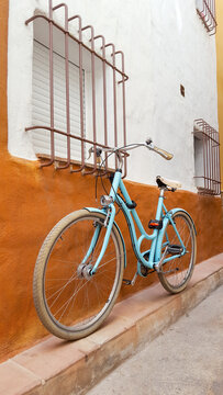 Vintage blue city bicycle against colorful Mediterranean wall