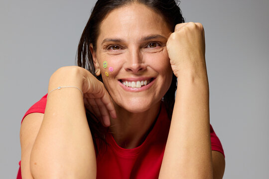 Smiling Woman With Stickers on Her Face Showing Joy and Fun
