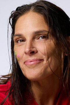 Woman With Wet Hair Smiles Wearing Colorful Stickers on Her Face