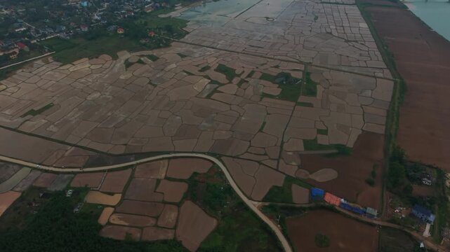 Fields In Harmony. Flooded Farmland Creates Artistic Designs. Seasonal Irrigation Crafts Intricate Rural Imagery. Surreal Aerial View Of Waterlogged Rice Fields With Geometric Shapes