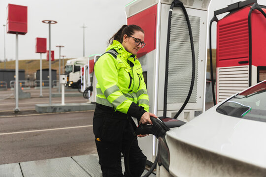 Technician Connecting Electric Car at Charging Station