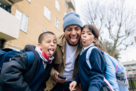 Farther picking up children from school having fun