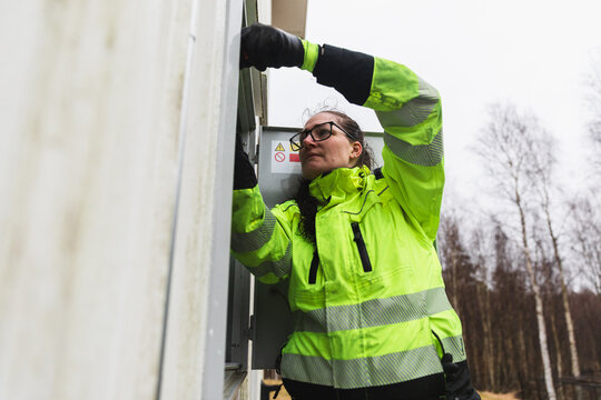 Female technician inspecting building service panel
